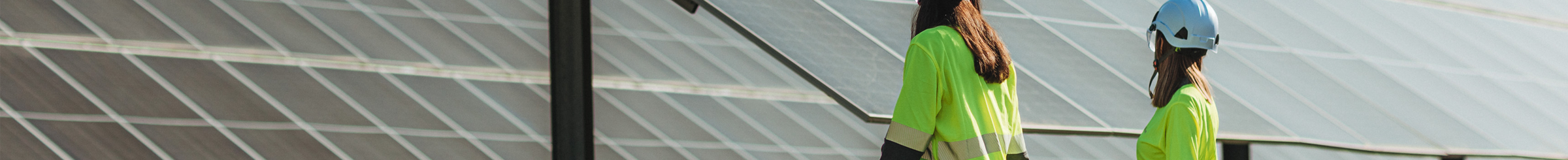 Campo con pannelli fotovoltaici e lavoratori Statkraft che camminano