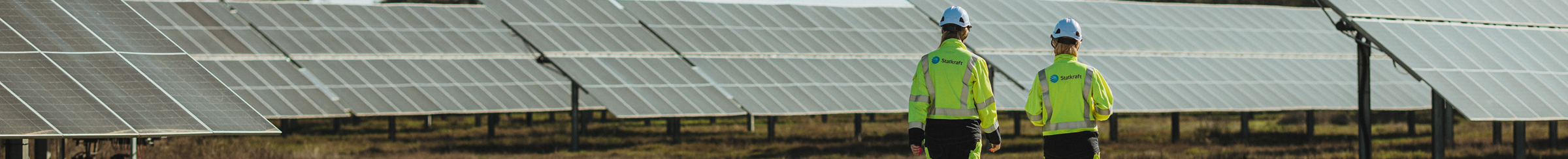 Due tecnici Statkraft passeggiano in un parco solare
