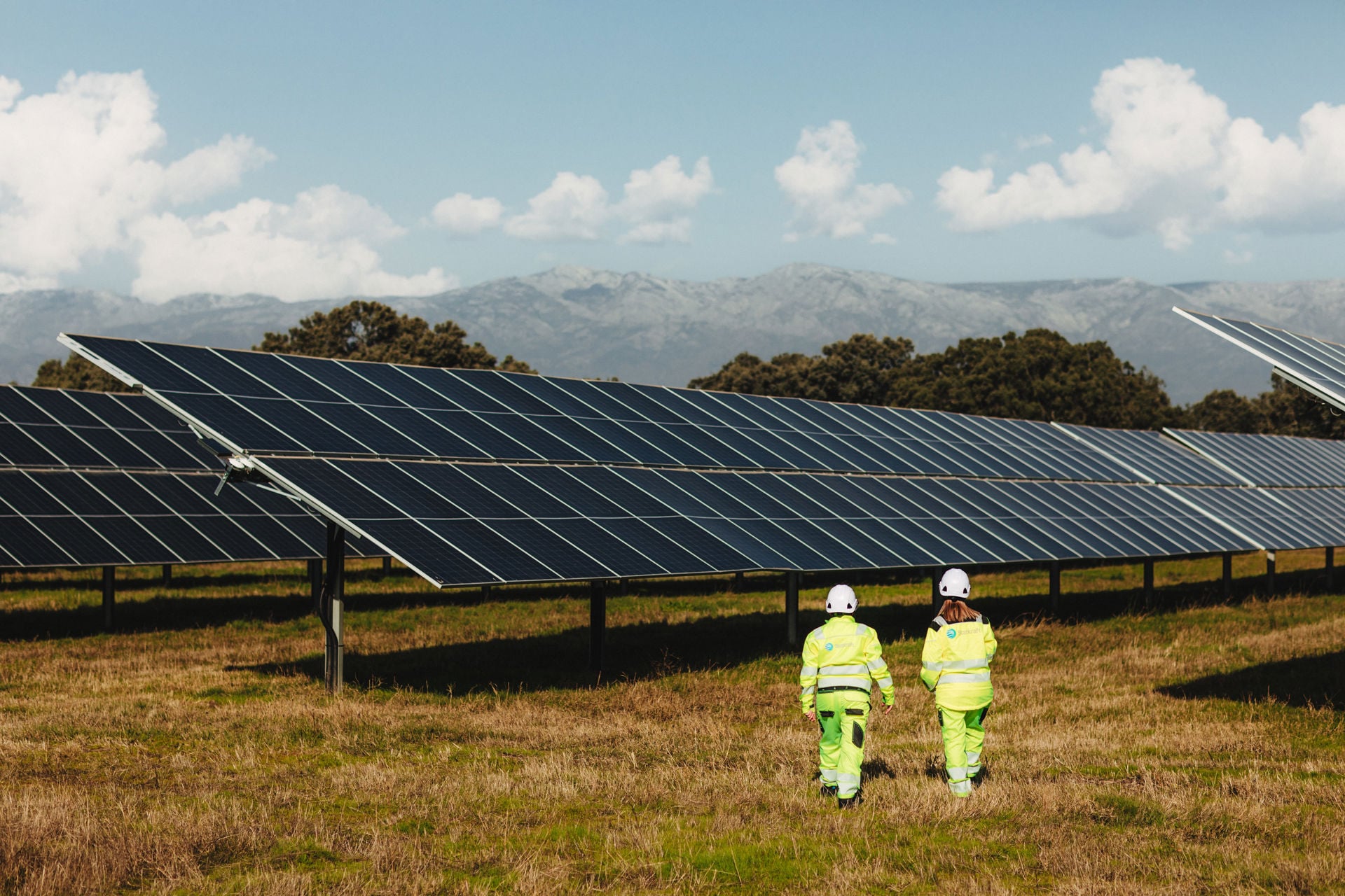 Uomo che cammina accanto a un pannello fotovoltaico