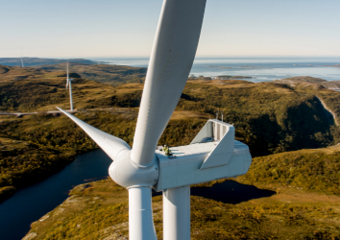 Pala eolica con scogliere e mare sullo sfondo