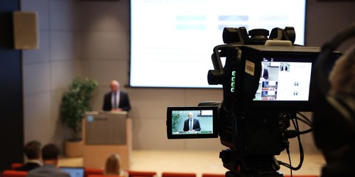 Uomo in conferenza, ripreso da un telecamera