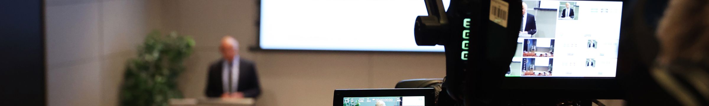 Uomo in conferenza, ripreso da un telecamera